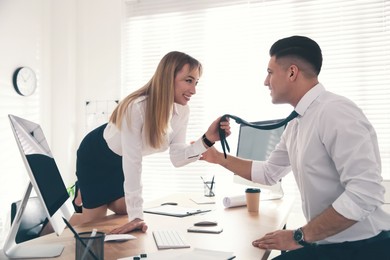 Colleagues flirting with each other during work in office. Cheating concept
