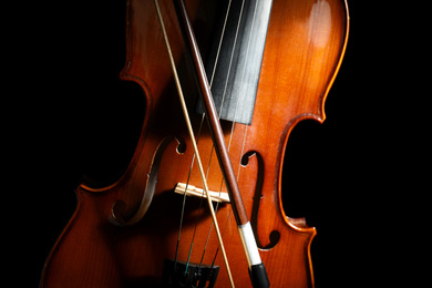 Classic violin and bow on black background, closeup