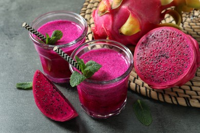 Delicious pitahaya smoothie, fruits and fresh mint on grey table