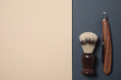 Shaving brush and straight razor on color background, flat lay. Space for text