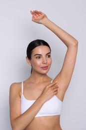Photo of Young woman showing smooth skin after epilation on white background