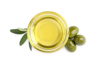 Glass bowl of oil, ripe olives and green leaves on white background, top view