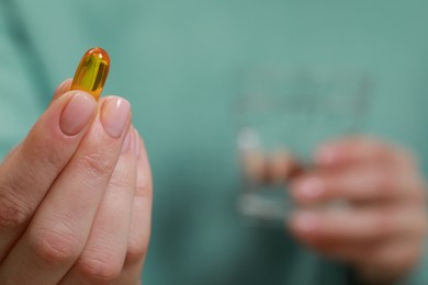 Woman holding one pill, closeup of hand. Space for text