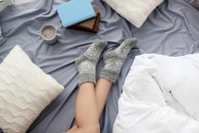 Young woman lying on bed, closeup view of legs. Winter atmosphere