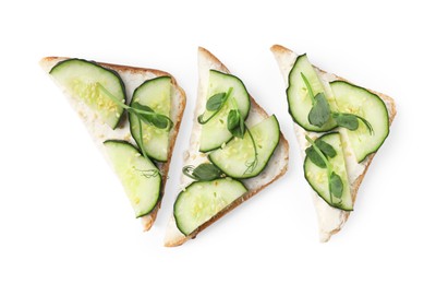Tasty cucumber sandwiches with sesame seeds and pea microgreens on white background, top view