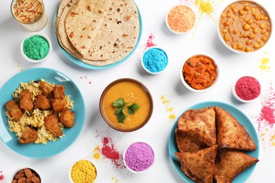 Traditional Indian food and color powder dyes on light background, flat lay. Holi festival