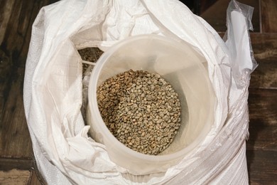 Raw coffee beans in sack, above view