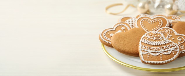 Image of Tasty heart shaped gingerbread cookies on white wooden table, space for text. Banner design