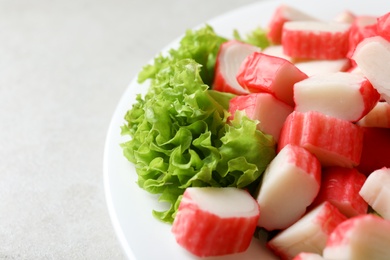 Cut crab sticks and lettuce on light table, closeup