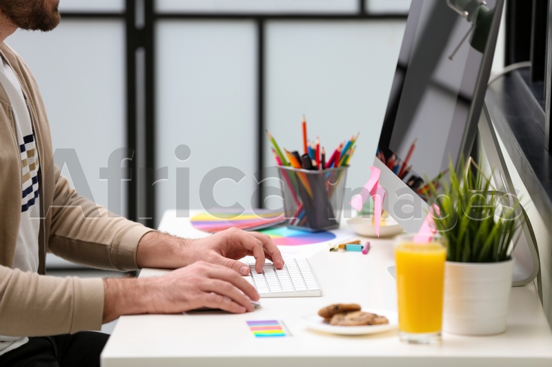 Male designer working at desk in office, closeup