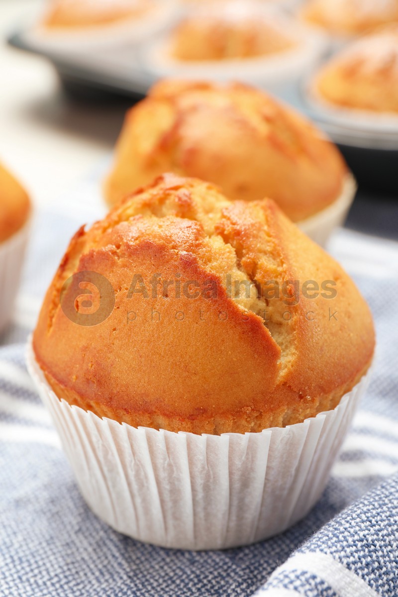 Photo of Tasty muffin in paper cup on table, closeup