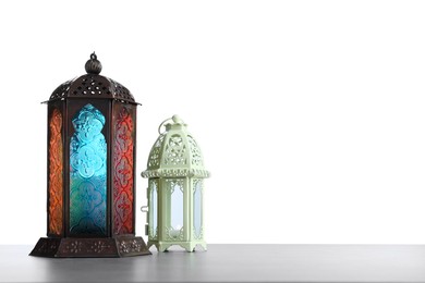 Decorative Arabic lanterns on grey table against white background