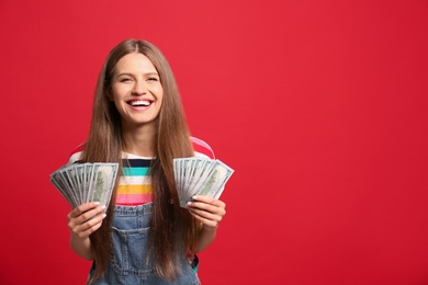 Portrait of happy lottery winner with money on red background, space for text