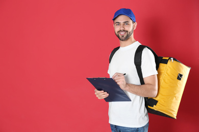 Courier with thermo bag and clipboard on red background, space for text. Food delivery service