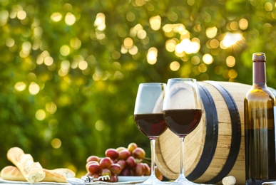 Photo of Composition with barrel of wine and snacks on table at vineyard, space for text
