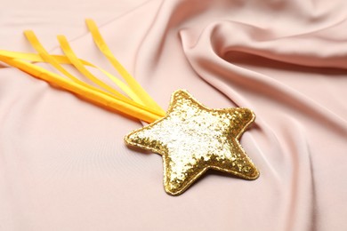 Beautiful golden magic wand on pink fabric