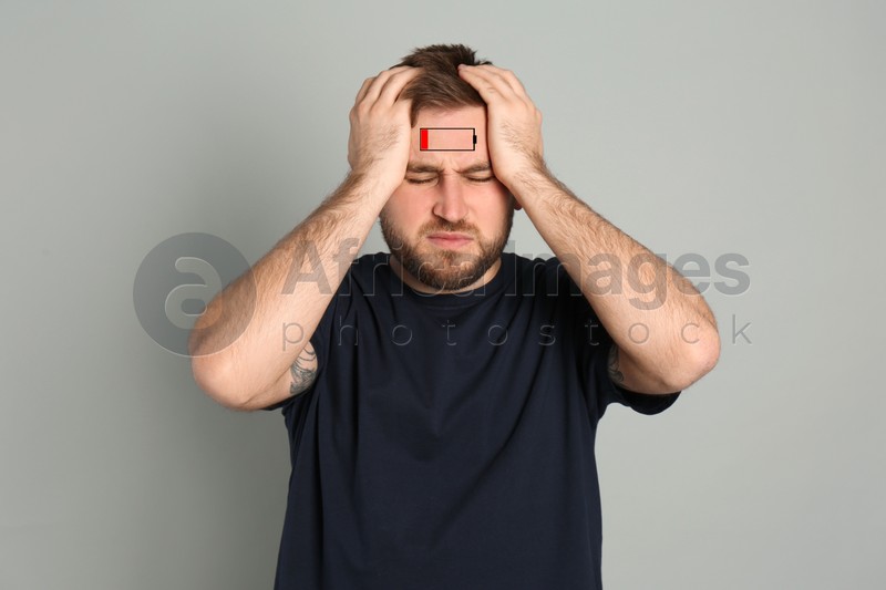 Illustration of discharged battery and tired man on light grey background. Extreme fatigue