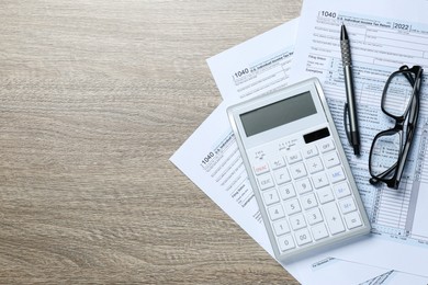 Calculator, documents, glasses and pen on wooden table, flat lay with space for text. Tax accounting