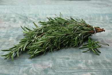 Bunch of fresh rosemary on light blue wooden table