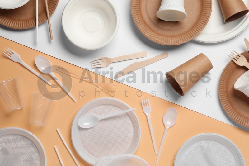 Photo of Flat lay composition with plastic and eco disposable tableware on color background