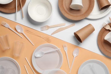 Flat lay composition with plastic and eco disposable tableware on color background