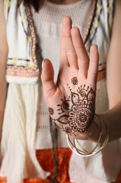Photo of Woman with henna tattoo on palm, closeup. Traditional mehndi ornament