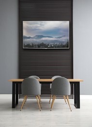 Image of Modern wide screen TV on wall in room with stylish furniture 