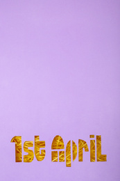 Phrase 1st APRIL cut out of lilac paper, top view with space for text. Fool's Day