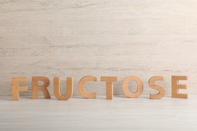 Photo of Word Fructose made of wooden letters on table