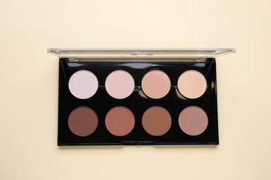 Photo of Colorful contouring palette on beige background, top view. Professional cosmetic product