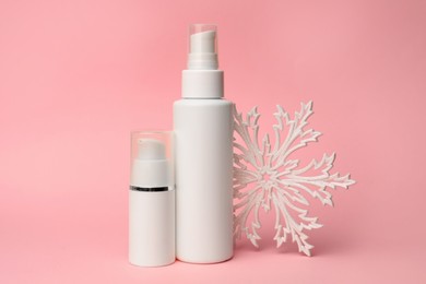 Photo of Winter skin care. Stylish presentation of hand cream sprays on pink background