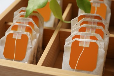 Paper tea bags with tags in wooden box , closeup
