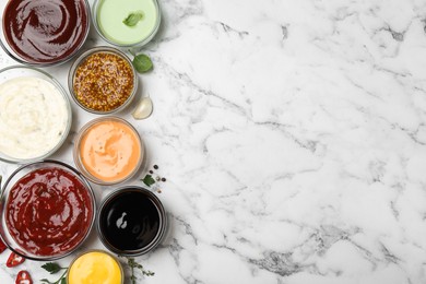 Many different sauces and herbs on white marble table, flat lay. Space for text