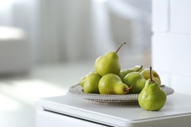 Fresh ripe pears on white table in room. Space for text