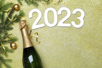 Happy New Year 2023! Flat lay composition with bottle of sparkling wine on color background, space for text