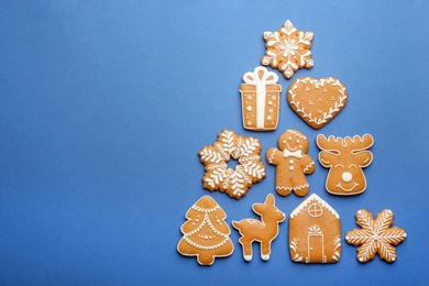Christmas tree shape made of delicious gingerbread cookies on blue background, flat lay. Space for text