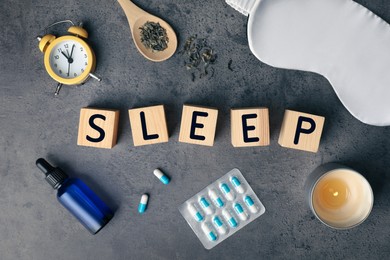 Flat lay composition with word Sleep made of wooden cubes and insomnia remedies on grey background