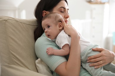 Photo of Young woman with her cute baby at home