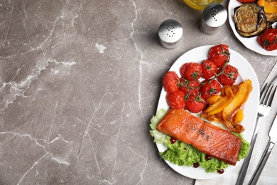Photo of Tasty cooked salmon and vegetables served on grey table, flat lay with space for text. Healthy meals from air fryer