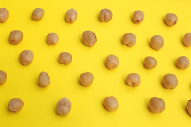 Tasty organic hazelnuts on yellow background, above view