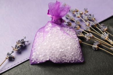 Scented sachet and dried lavender on black table, closeup