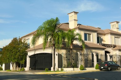 Photo of Beautiful modern house and palm trees in city street