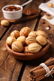 Photo of Homemade walnut shaped cookies with boiled condensed milk on wooden table