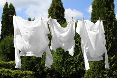 Clean clothes hanging on washing line in garden. Drying laundry