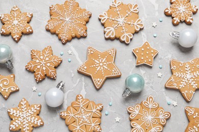 Tasty Christmas cookies and baubles on light grey marble table, flat lay