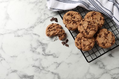 Delicious chocolate chip cookies on white marble table, flat lay. Space for text