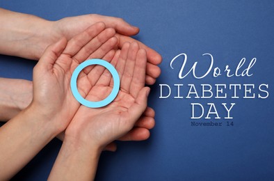 People showing blue paper circle as World Diabetes Day symbol on color background, top view 
