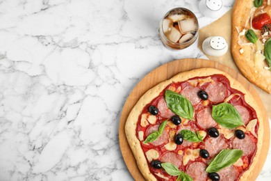 Delicious homemade pita pizza and cold drink on white marble table, flat lay. Space for text