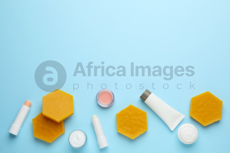 Flat lay composition with beeswax and cosmetic products on light blue background. Space for text