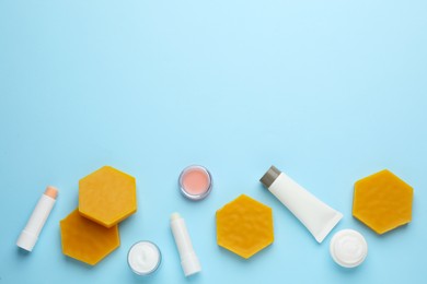 Flat lay composition with beeswax and cosmetic products on light blue background. Space for text